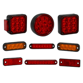 Assorted red and amber trailer lights and reflectors arranged on a white background