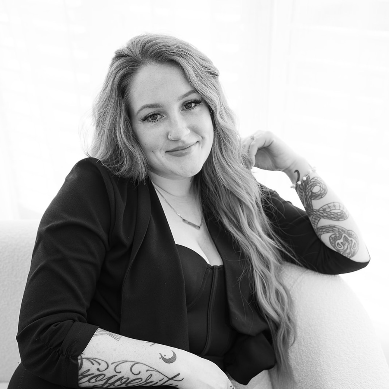 A black and white photo of a woman sitting on a chair.