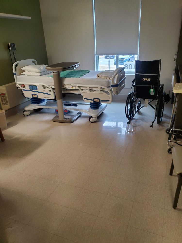There is a hospital bed and a wheelchair in the room