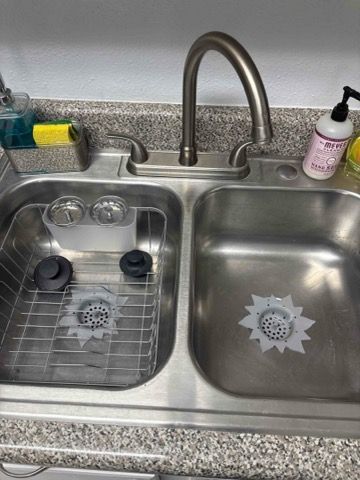 A stainless steel kitchen sink with two sinks and a faucet