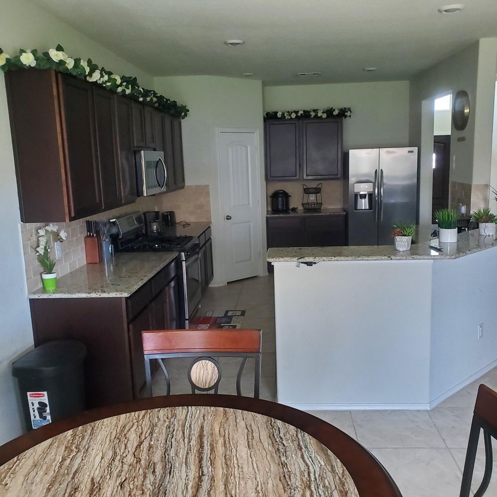 A kitchen with stainless steel appliances and a round table