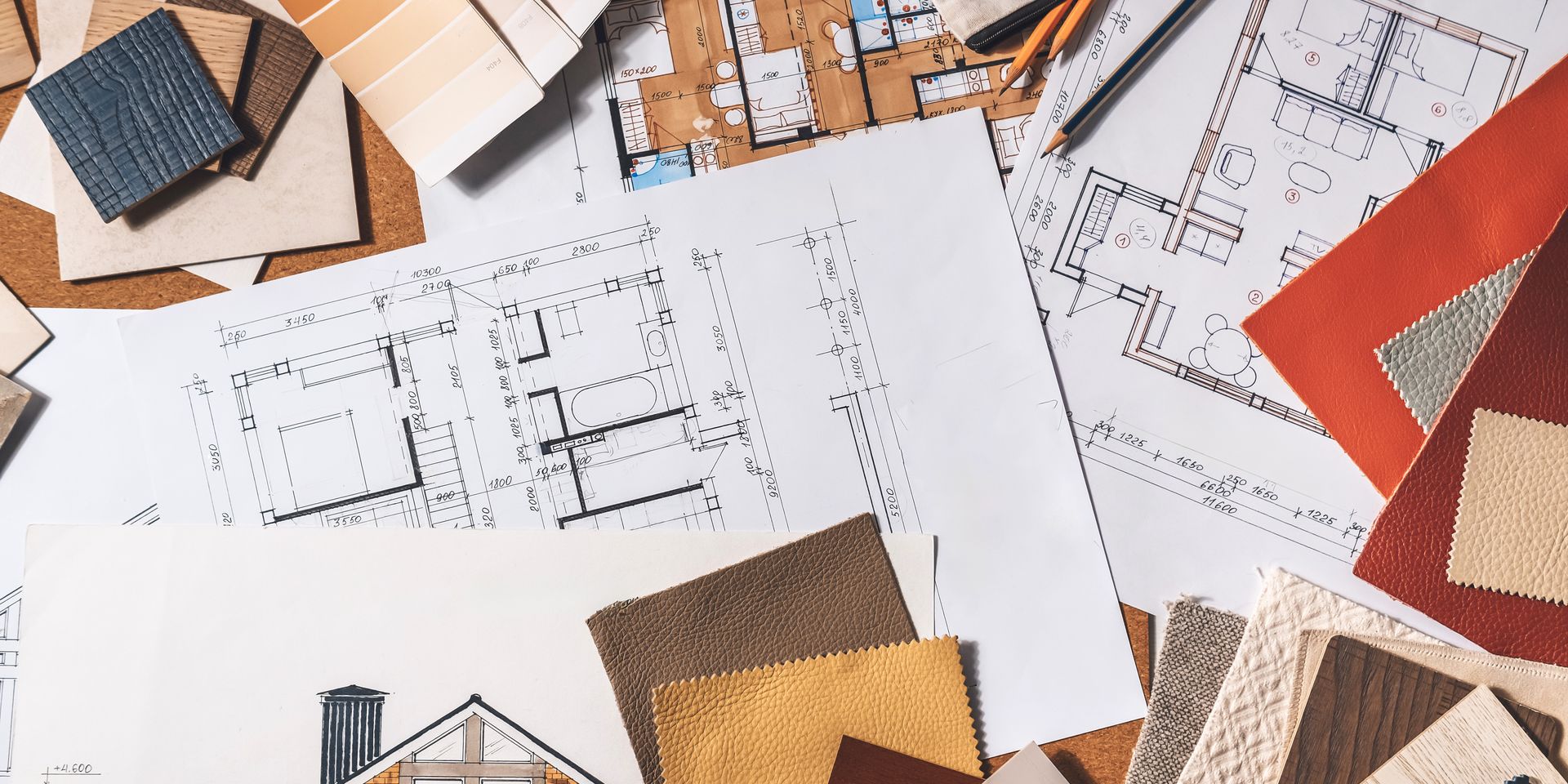 Home renovation plans spread out on a table before a renovation with WS Design & Build