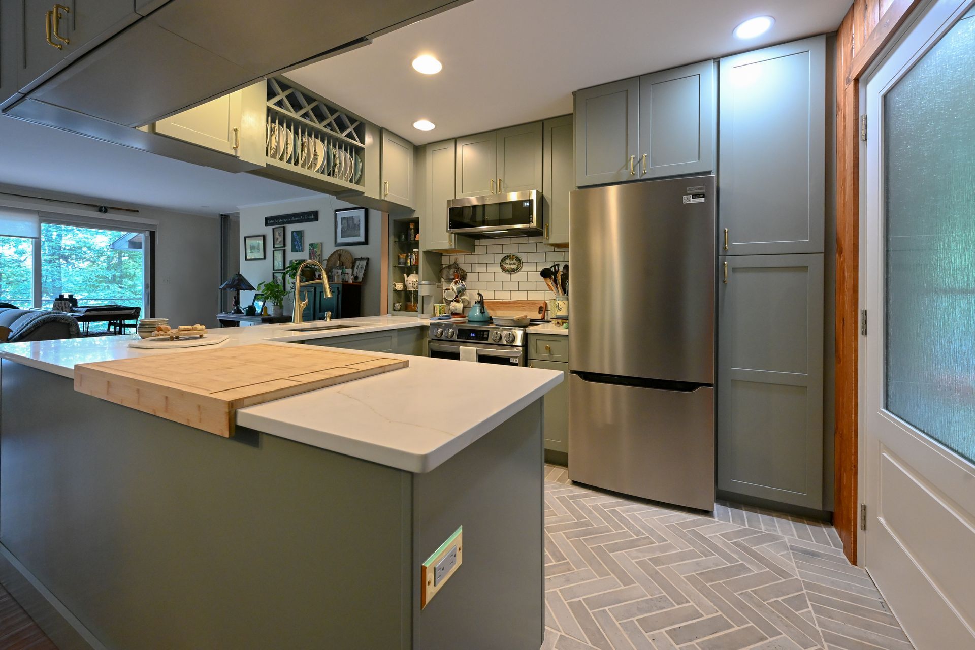 Kitchen with gray cabinets, stainless steel refrigerator, and herringbone tile floor. Kitchen with gray cabinets, stainless steel refrigerator, and herringbone tile floor.