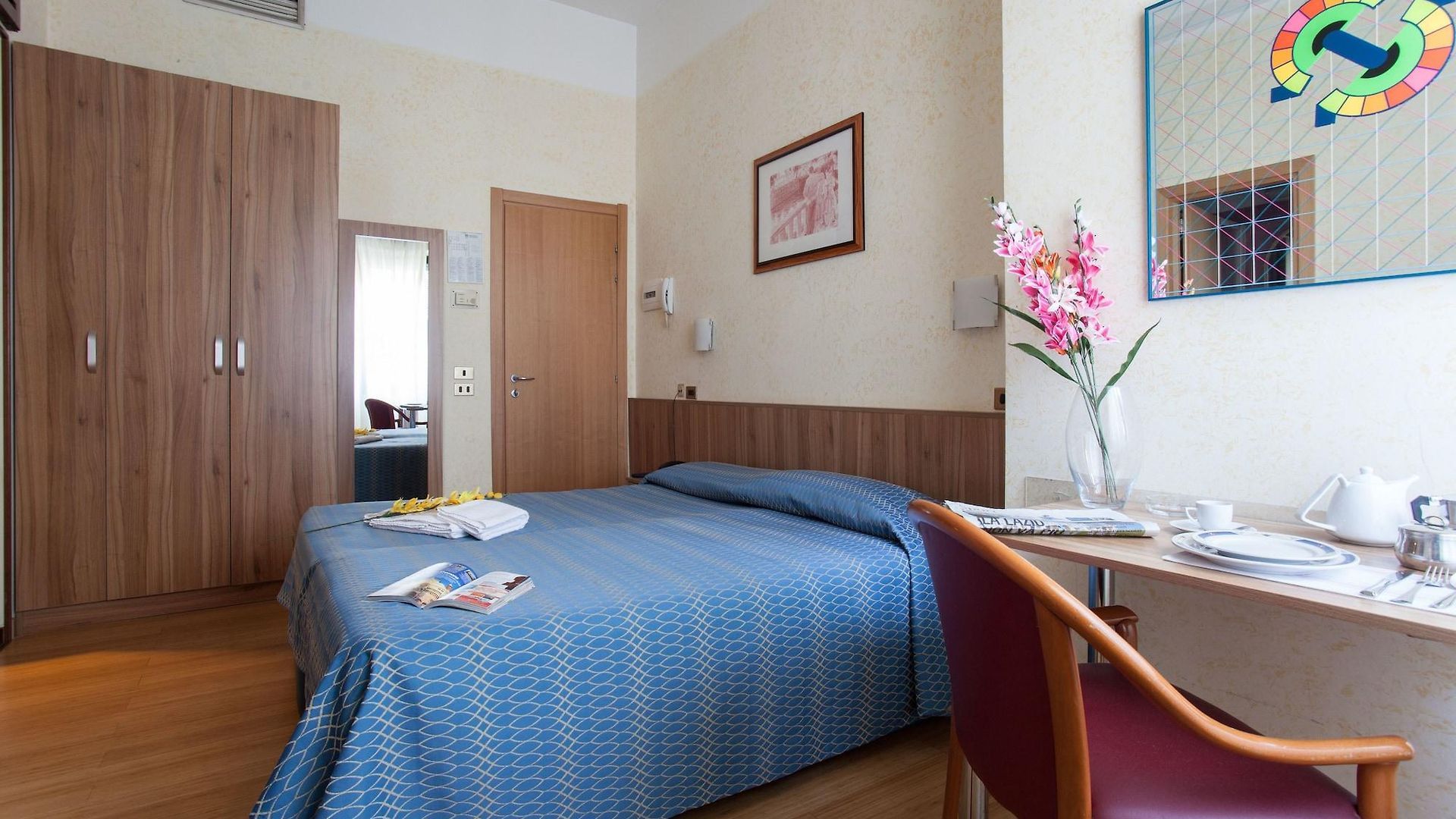 Una camera d'albergo con un letto, una scrivania e una sedia