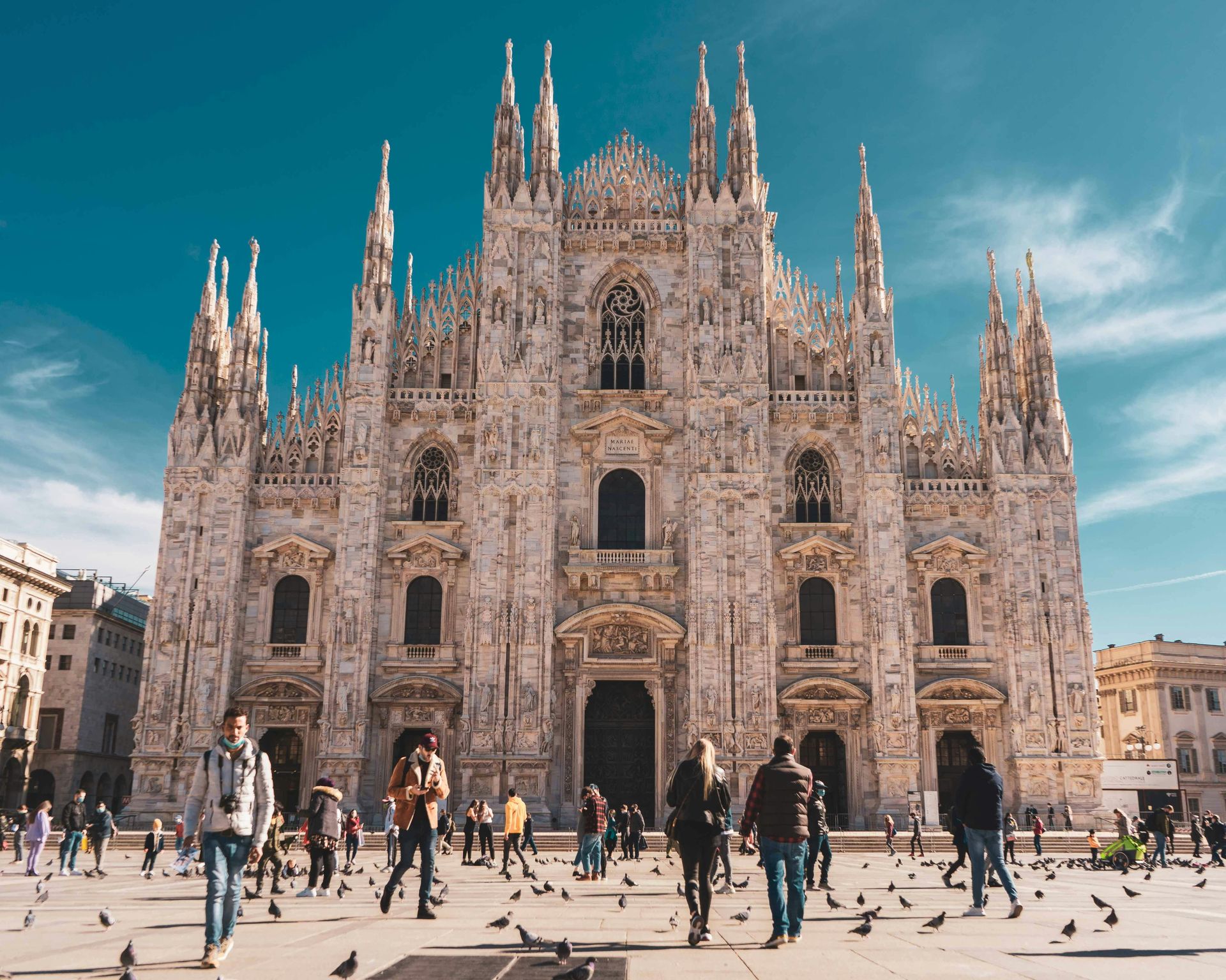 Un gruppo di persone cammina davanti al Duomo di Milano