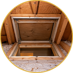 Open attic hatch with wooden frame and insulation around it