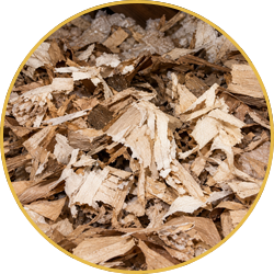 Close-up of light and dark wood chips mixed together, framed by a thin gold circle