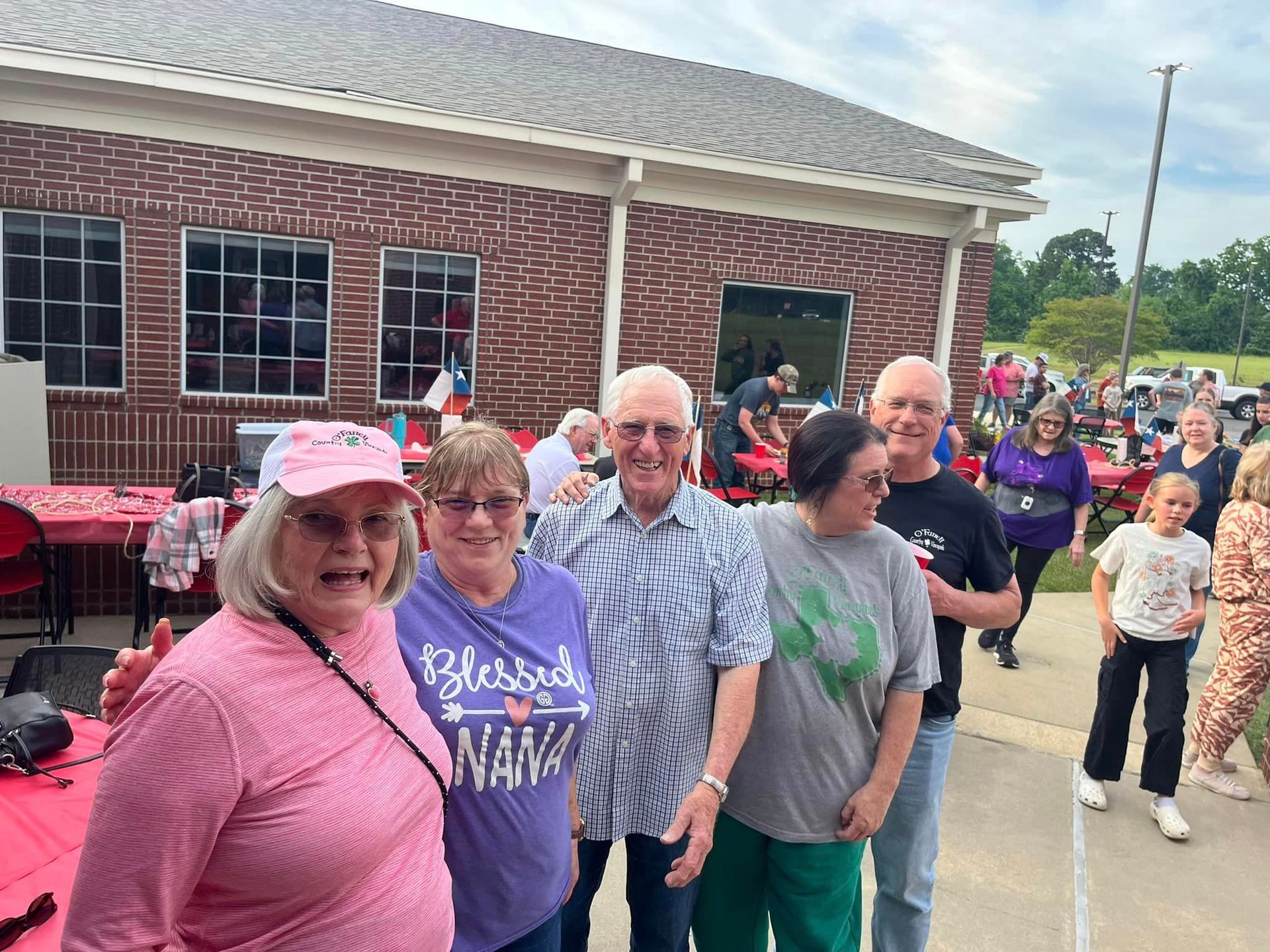 A group of people are posing for a picture in front of a building.