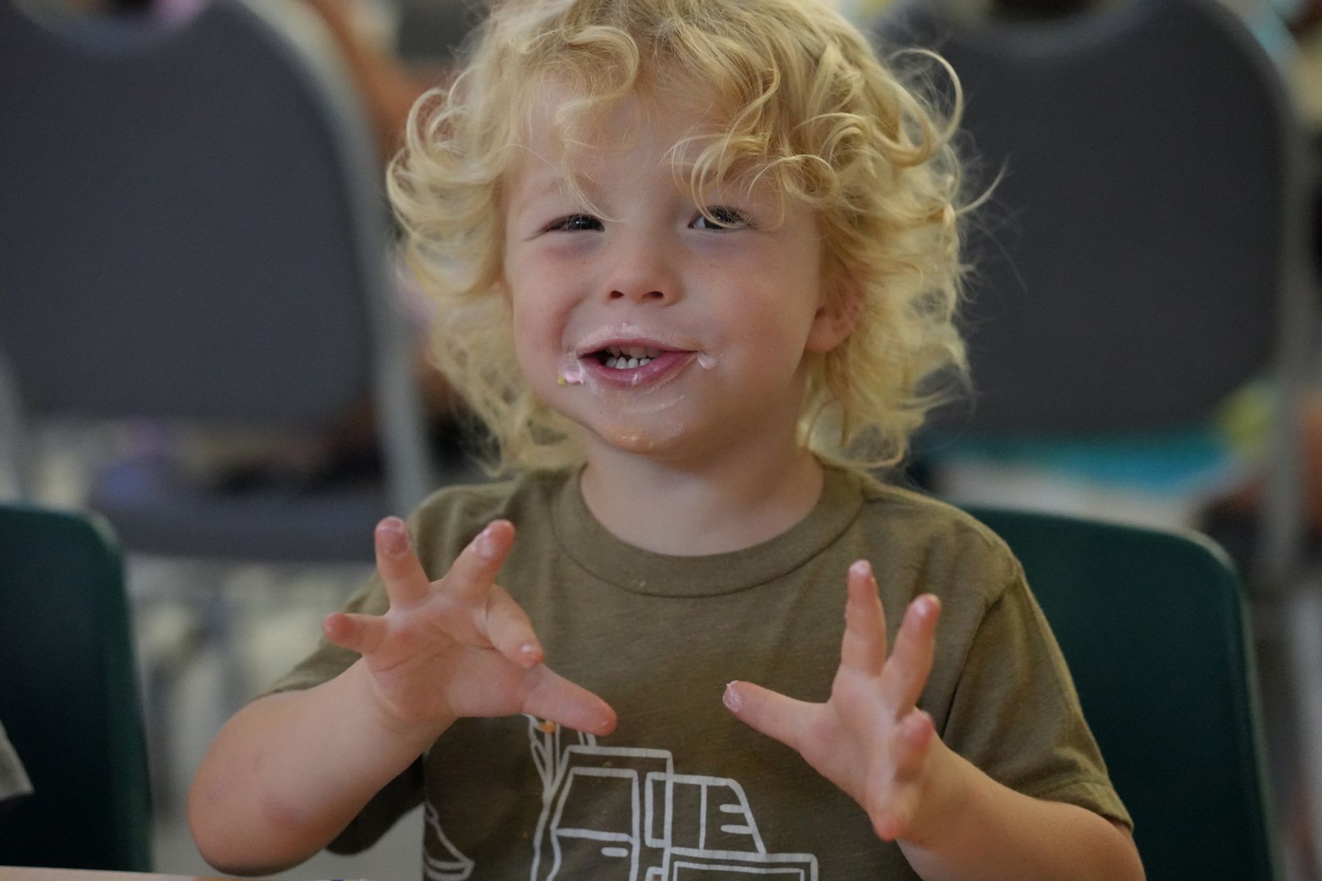 A young boy with a truck on his shirt is making a funny face