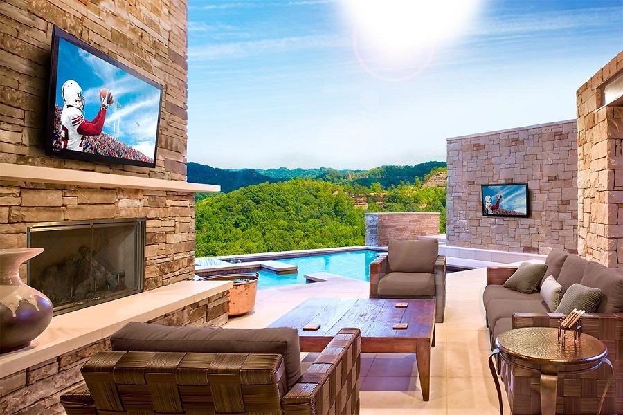 A living room with a couch , chairs , table , fireplace and television.