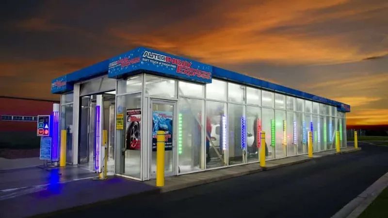A car wash with a lot of windows and a sunset in the background.