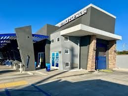 A large building with a lot of windows and doors is a car wash.