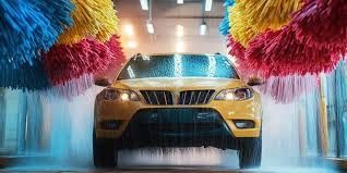A yellow car is going through a car wash.
