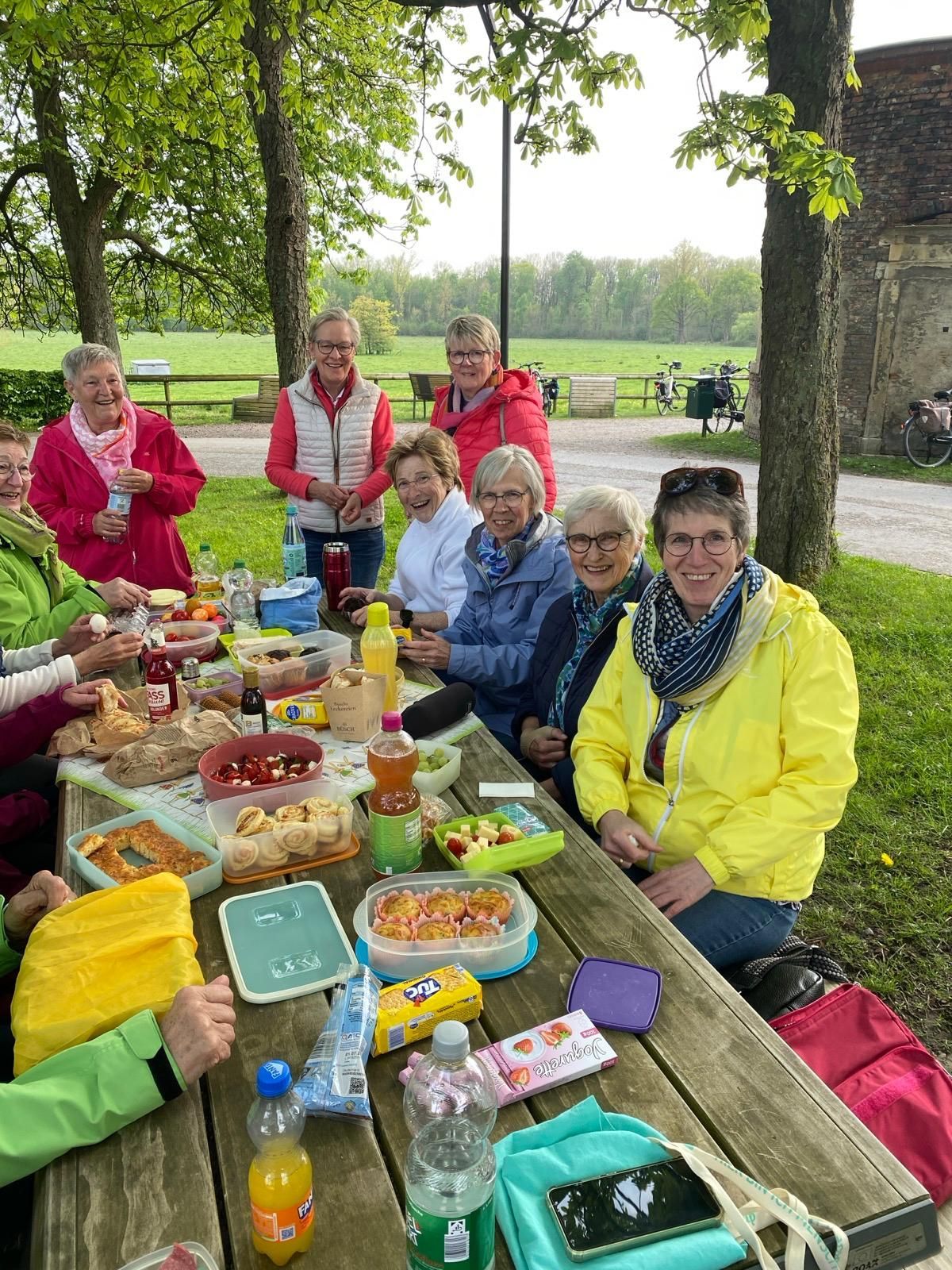Eine Gruppe von Leuten sitzt an einem Picknicktisch und isst.