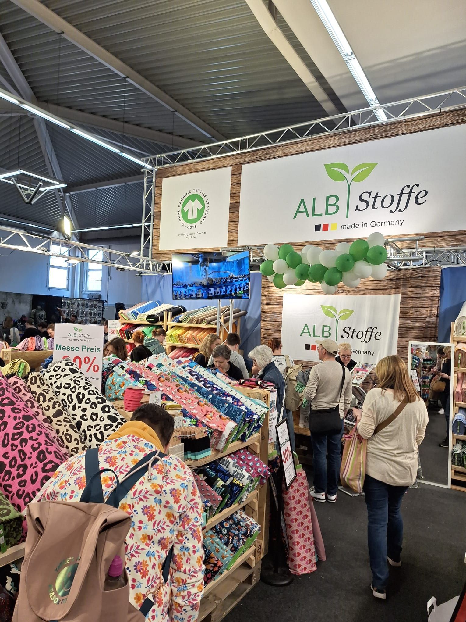 Eine Gruppe von Leuten geht in einem Stoffladen einkaufen.