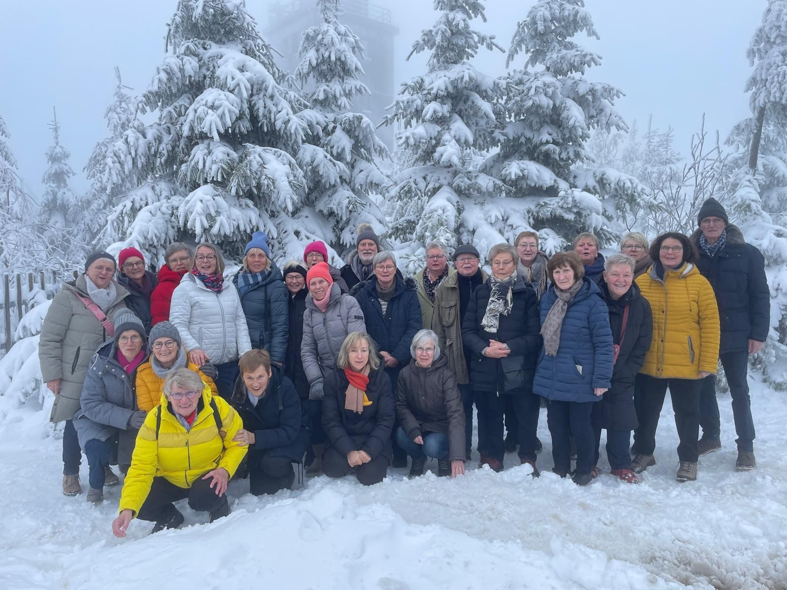 Eine Gruppe von Menschen posiert im Schnee für ein Foto.