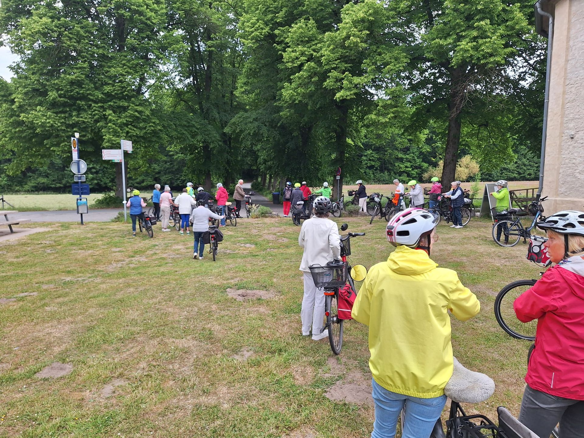 Eine Gruppe von Menschen fährt mit dem Fahrrad über eine Wiese.