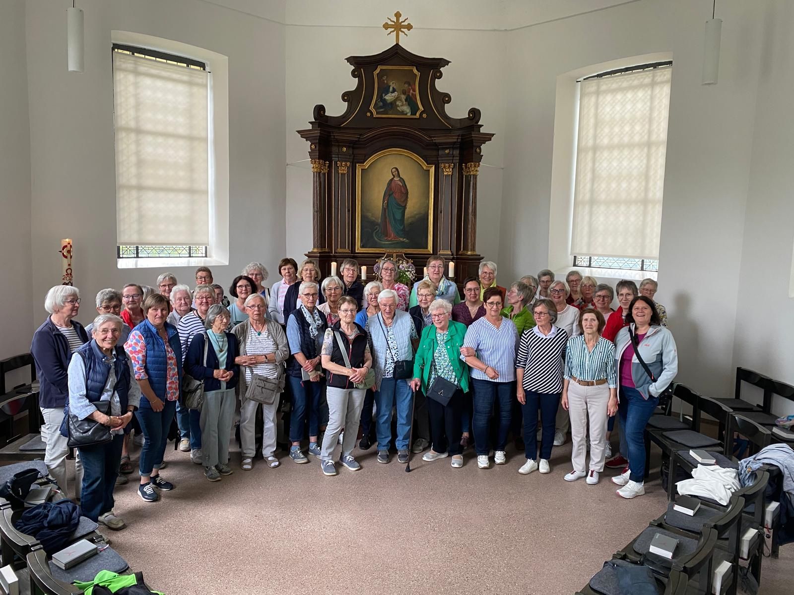 Eine große Gruppe von Menschen posiert in einer Kirche für ein Foto.