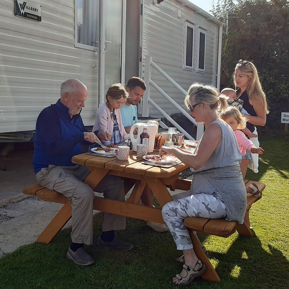 Family enjoying breakfast outside of a Static Caravan in Pennymoor Caravan and Camping Park