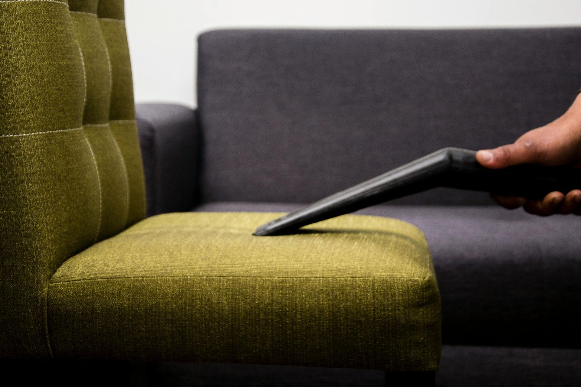 A vacuum cleaner is being used on a light beige carpet, removing dirt and leaving clean lines.