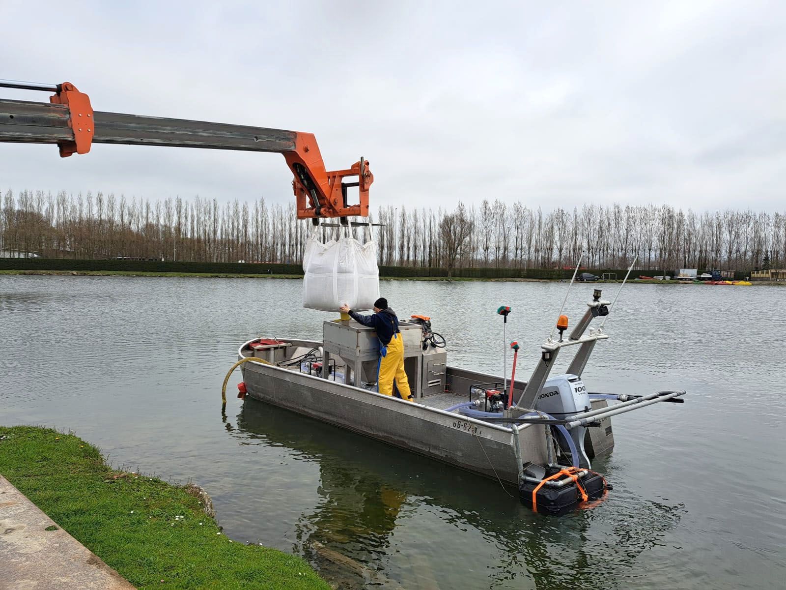 A man is loading a bag onto a boat in the water.