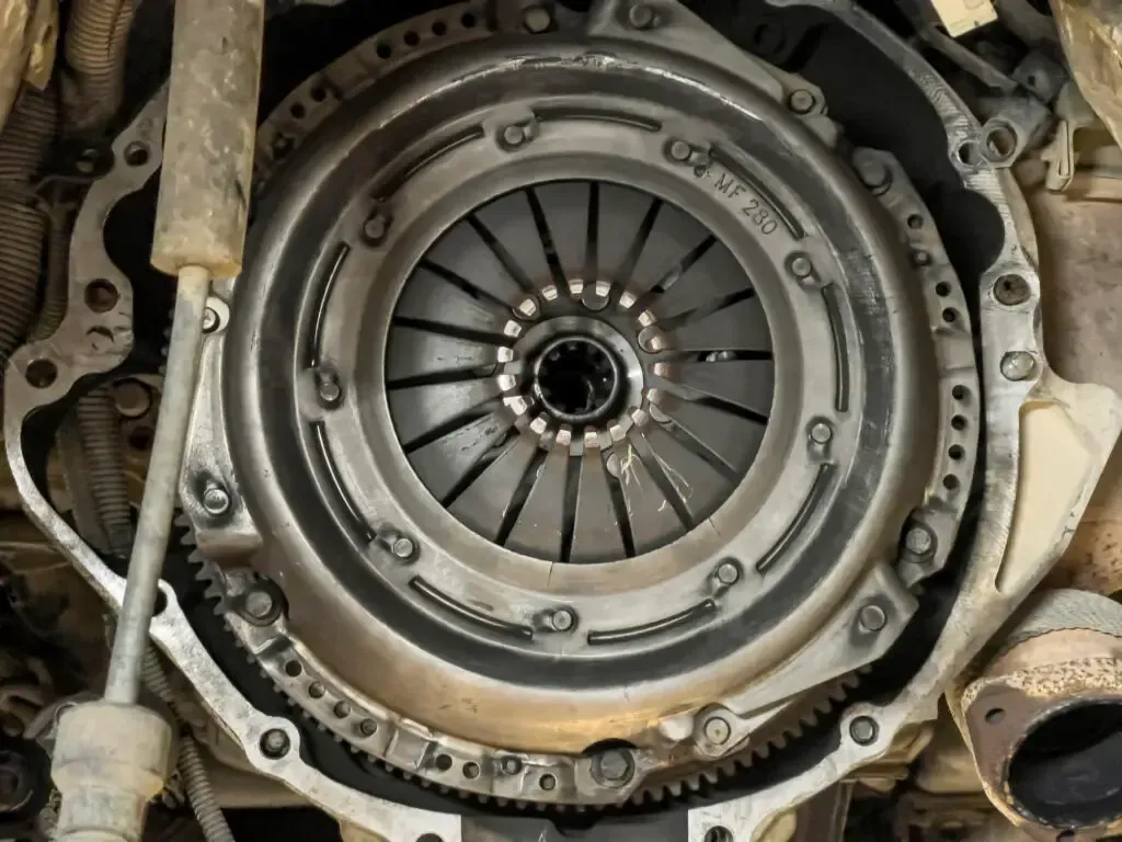 Automotive clutch assembly installed on a flywheel, showing the pressure plate and diaphragm spring mechanism.