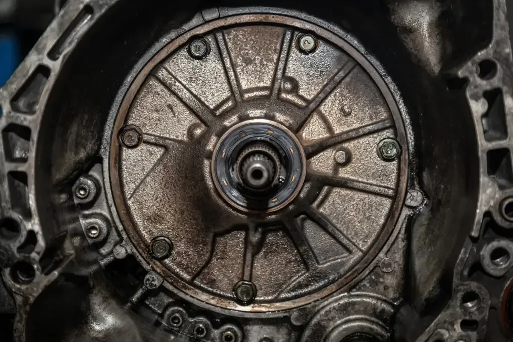 A close-up view of the metallic internal components of a vehicle transmission, showing a central shaft and ribbed housing.