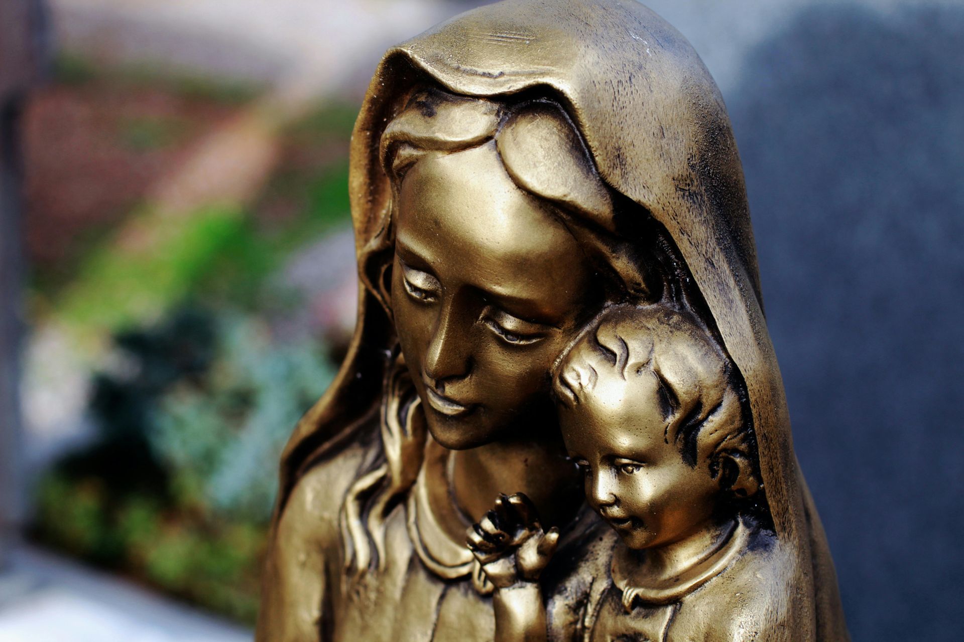 statua di rame con donna e bambino al cimitero