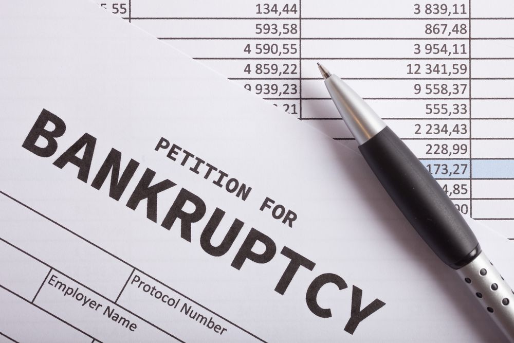 Pen, bankruptcy petition form with bold “BANKRUPTCY” text on desk