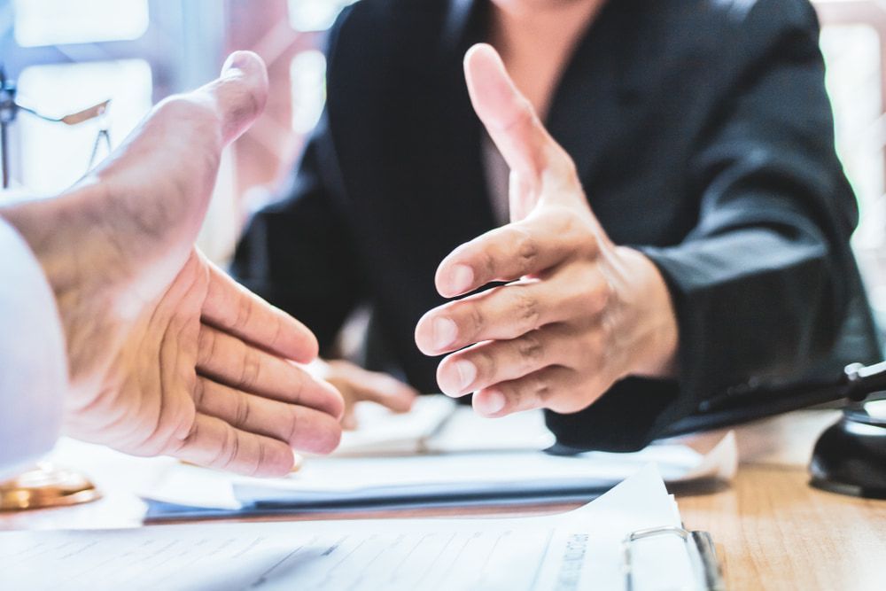 A Man and a Woman Are Shaking Hands Over a Table — Pola & Co In Warrnambool, VIC