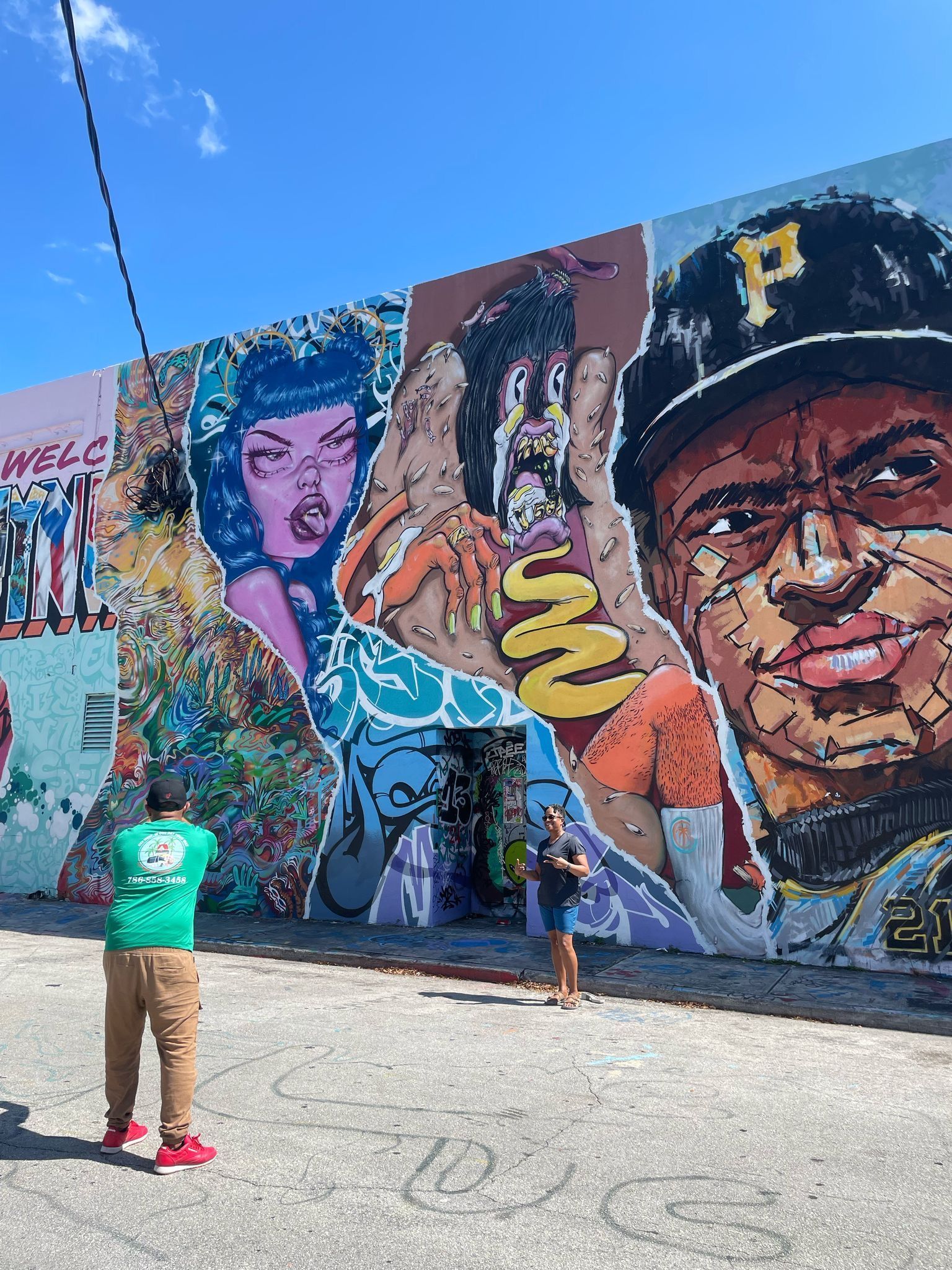 Guests on a Miami Sightseeing Bus Tour posing in front of the famous Wynwood graffiti wall
