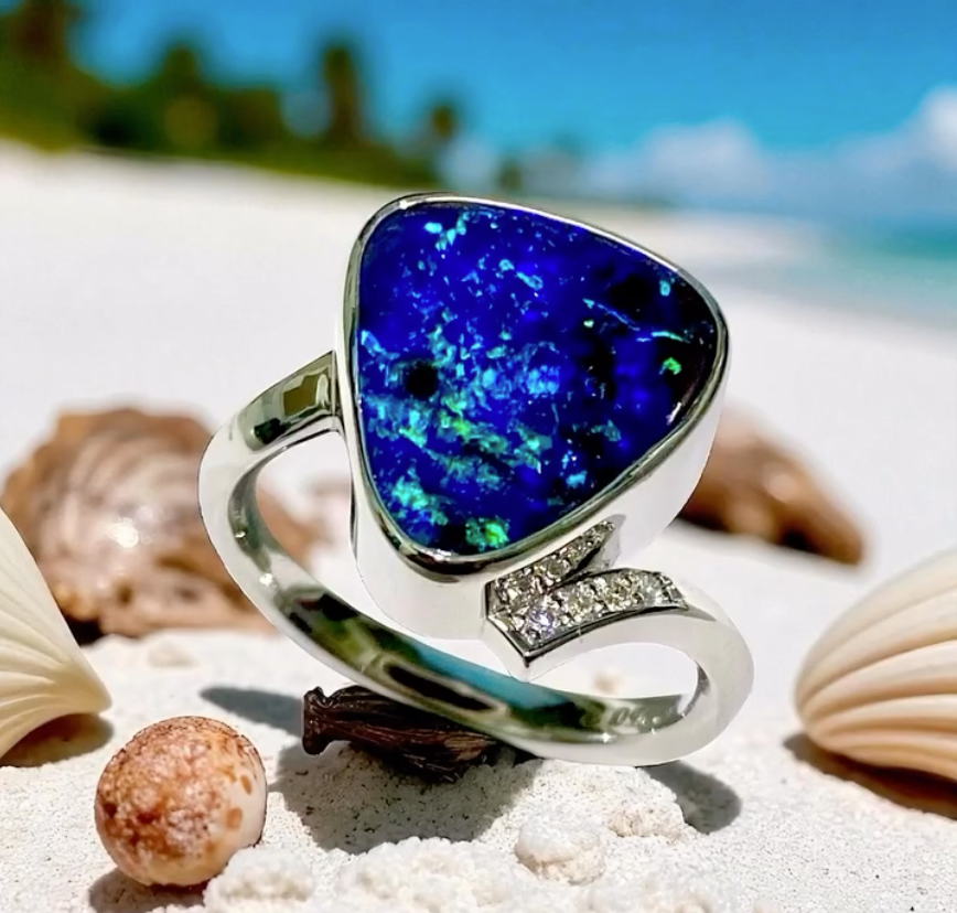 Silver Ring With Blue Opal Gemstone, Set on a Beach With Seashells — Regency Jewellers in Cairns City, QLD