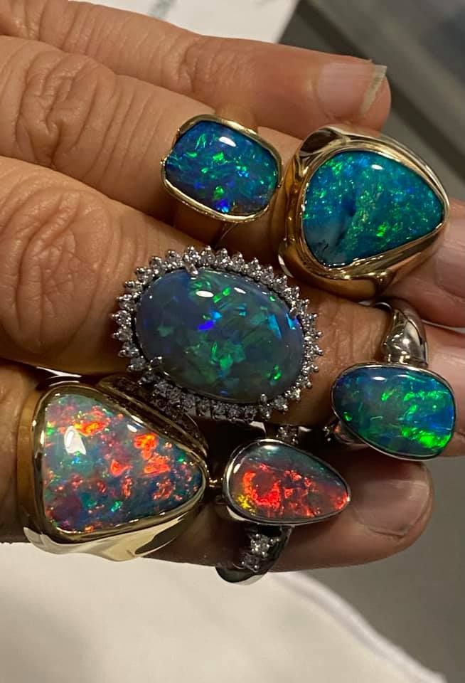 Hand Holding Multiple Opal Rings — Regency Jewellers in Cairns City, QLD