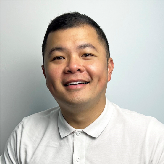 Smiling person in a white collared shirt against a light gray background