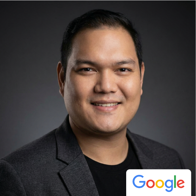 Portrait of a smiling person in a dark blazer with a Google logo in the corner