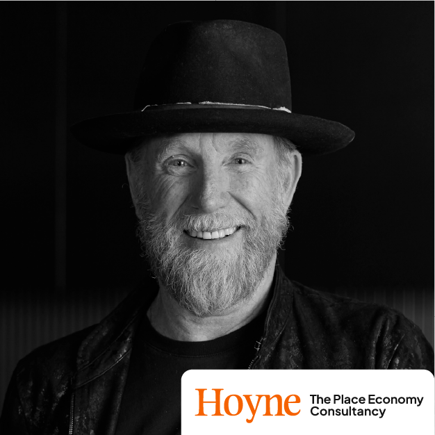 Smiling man in black hat and jacket with Hoyne The Place Economy logo