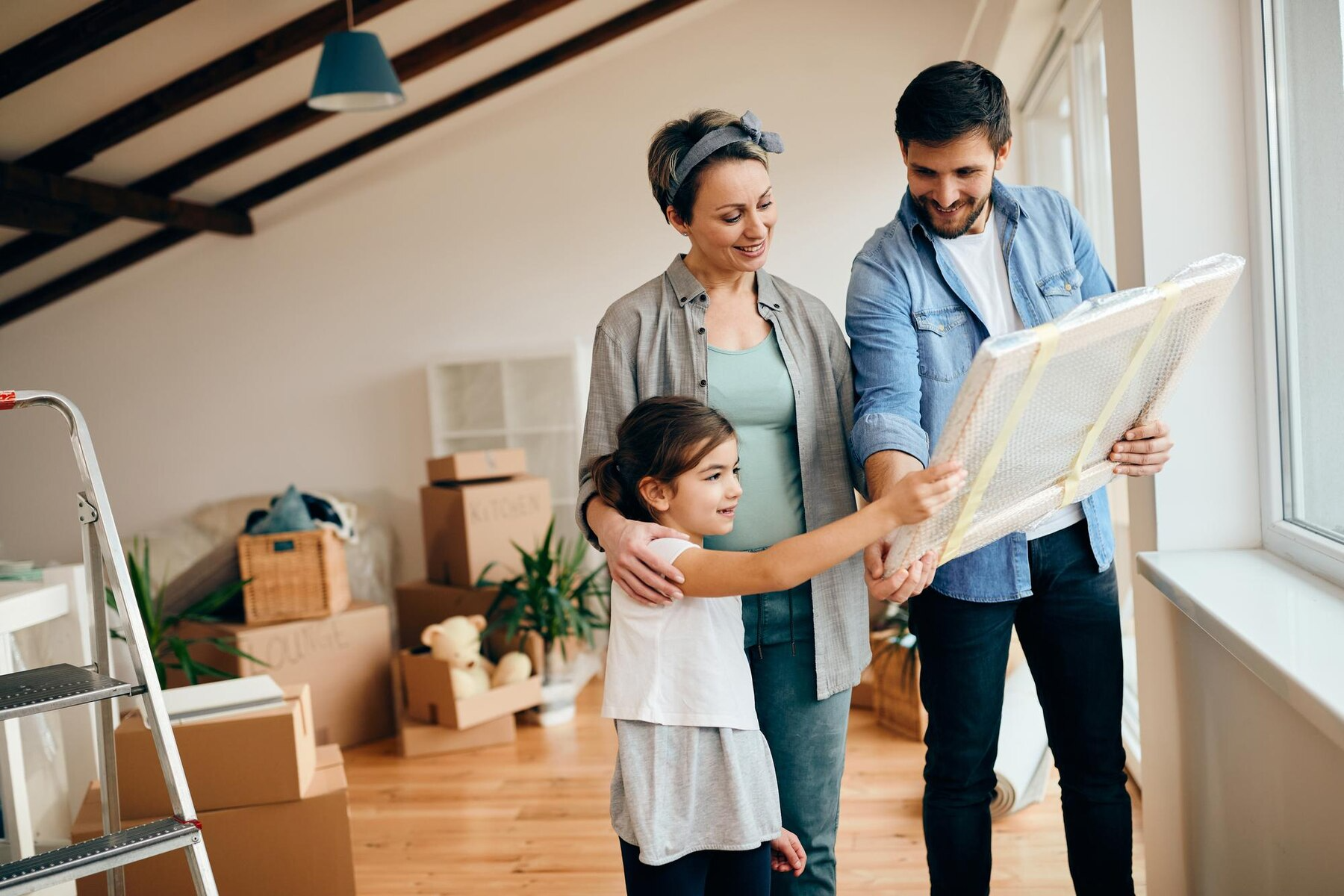 A family is looking at a picture in their new home.