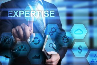 Businessman selecting digital icons with “EXPERTISE” text on a blue technology background