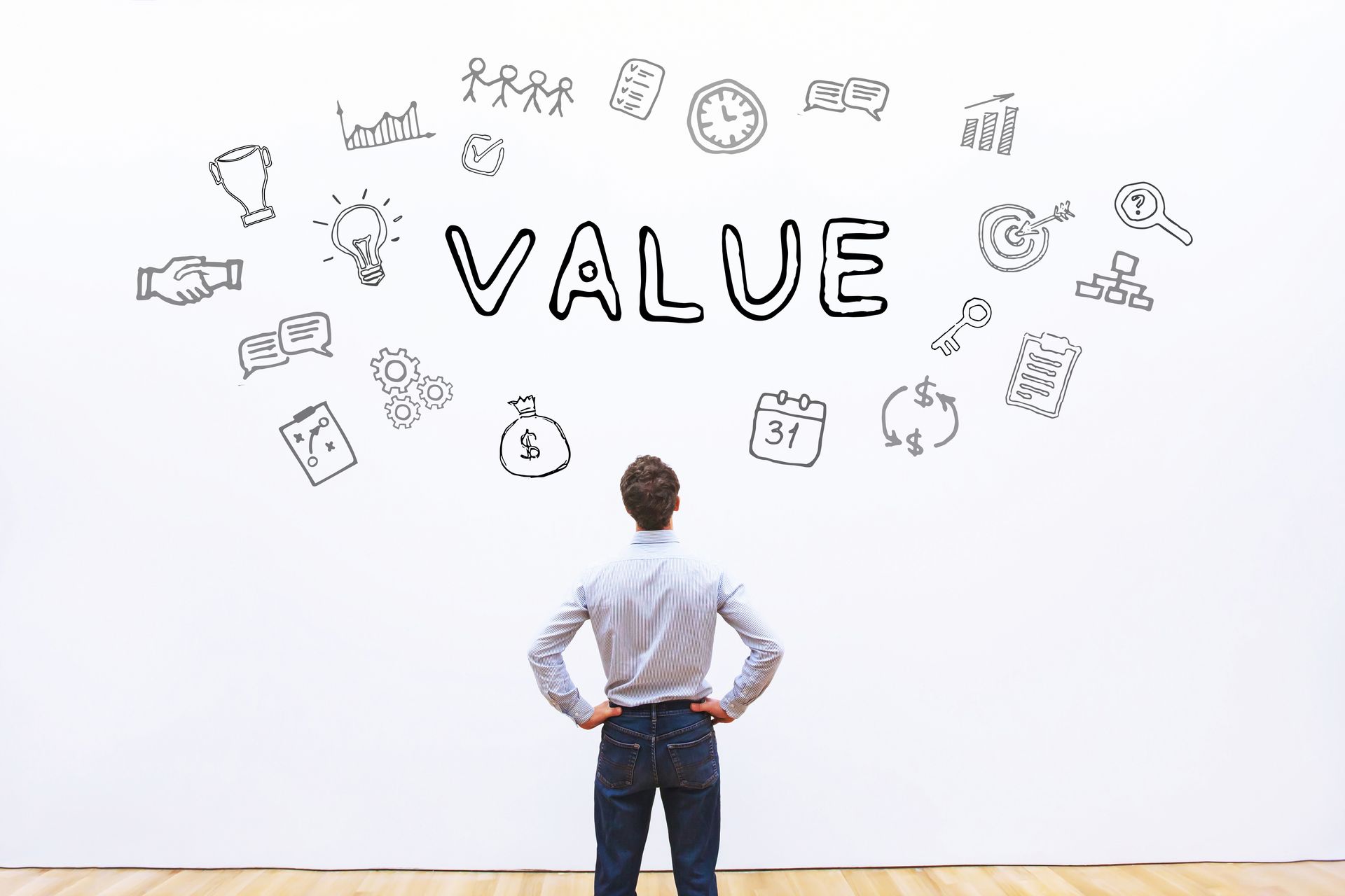 A man is standing in front of a wall with the word value written on it.