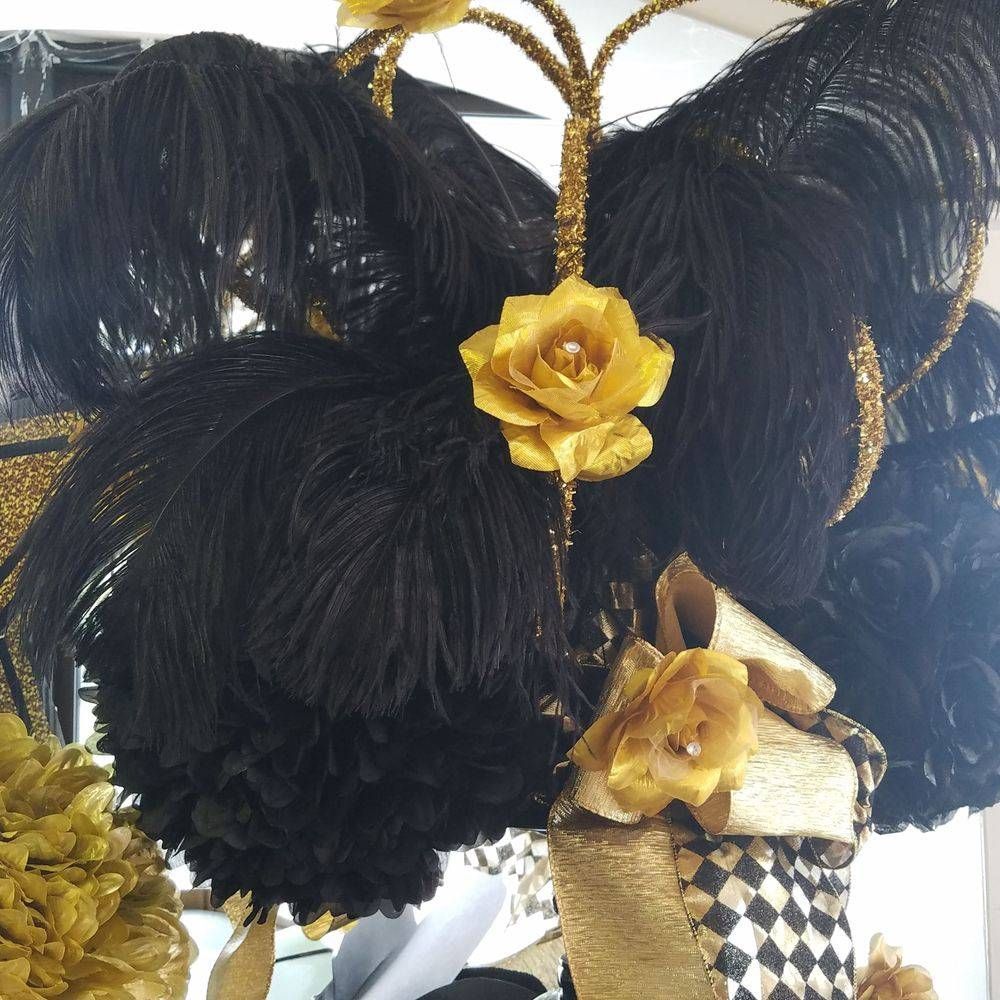 A black and gold feathered headpiece with gold flowers