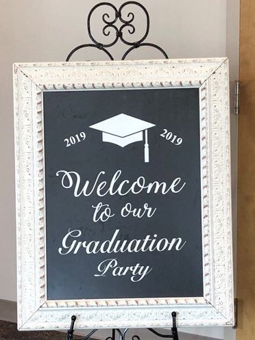 A welcome to our graduation party sign in a white frame.
