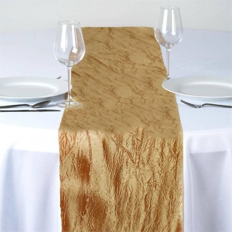 A table with plates and wine glasses and a gold table runner