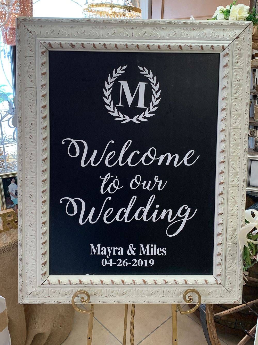 A welcome to our wedding sign in a white frame