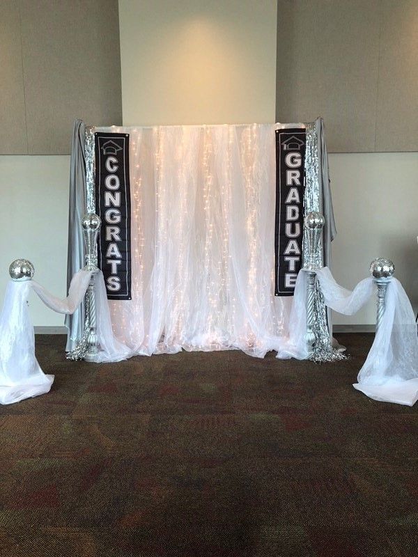 A room with a white curtain and two banners that say `` congratulations '' and `` graduate ''.