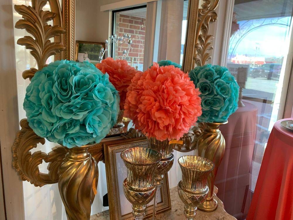 A table with vases filled with flowers and a mirror.
