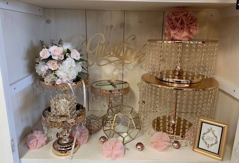 There are many different types of cake stands on the shelf.