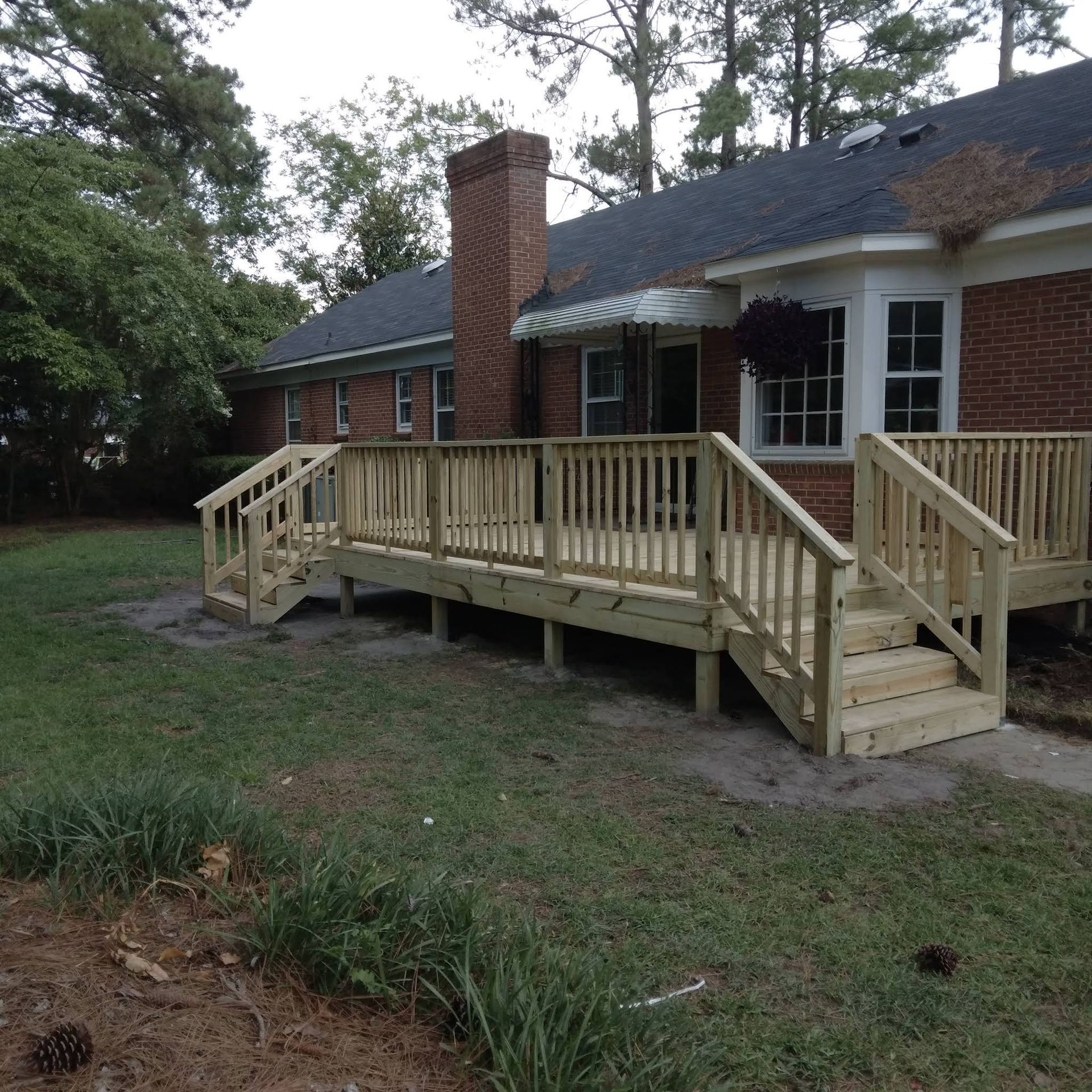 A brick house with a wooden deck in front of it