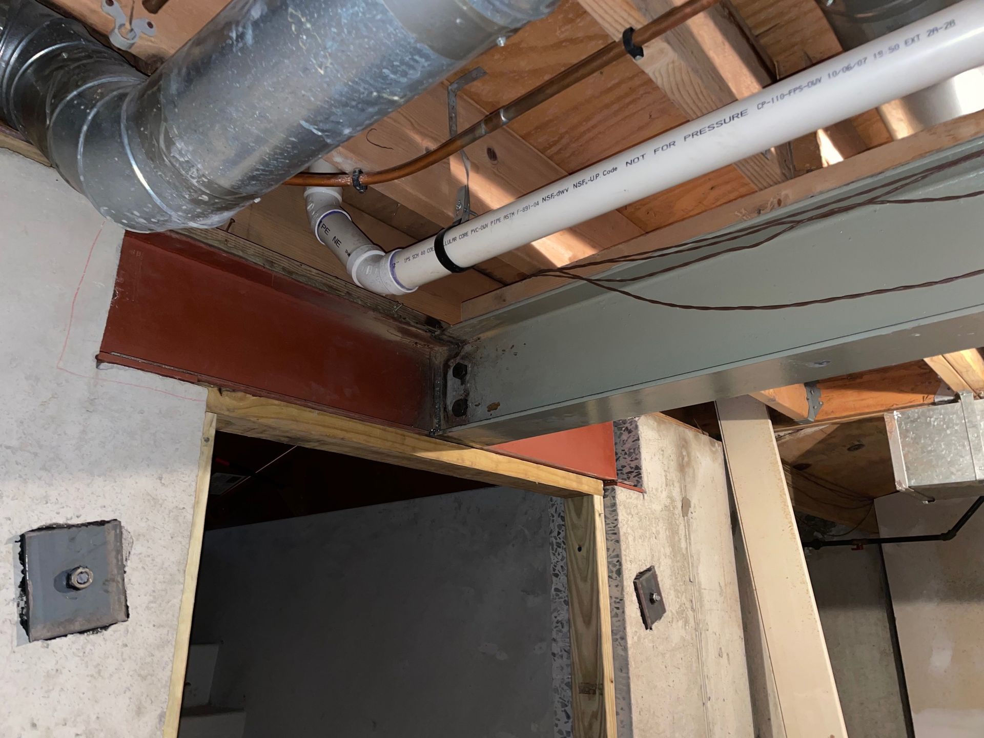 A pipe is hanging from the ceiling of a building.