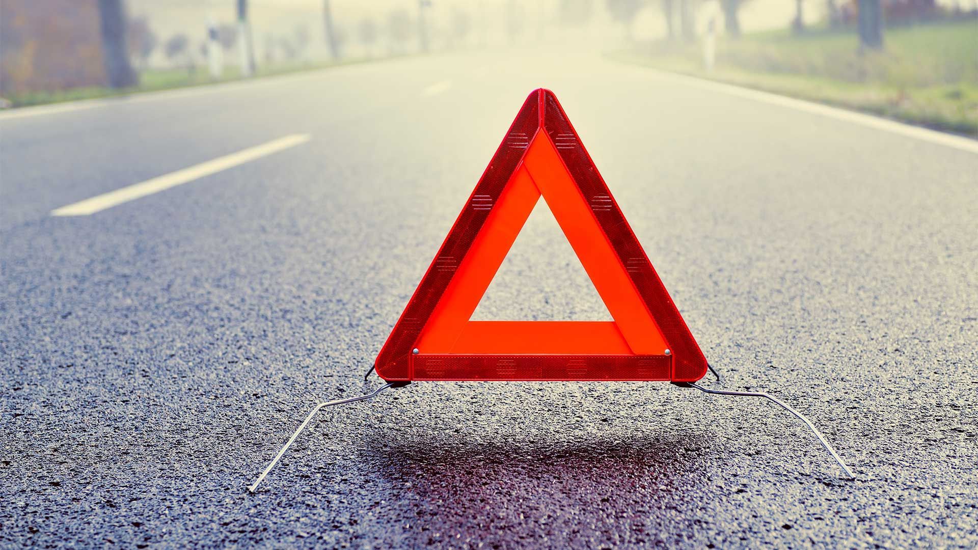 A red triangle is sitting on the side of a road.