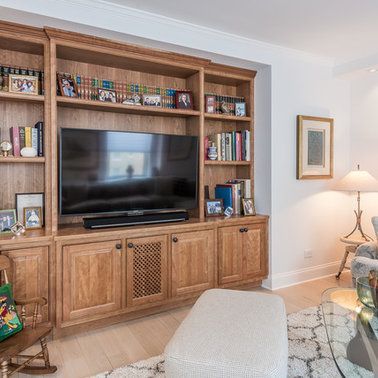 A living room with a large flat screen tv on a wooden entertainment center.